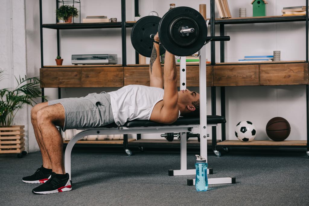 musculosa carrera mixta hombre entrenamiento con barra de pesas en casa gimnasio
  - Foto, Imagen