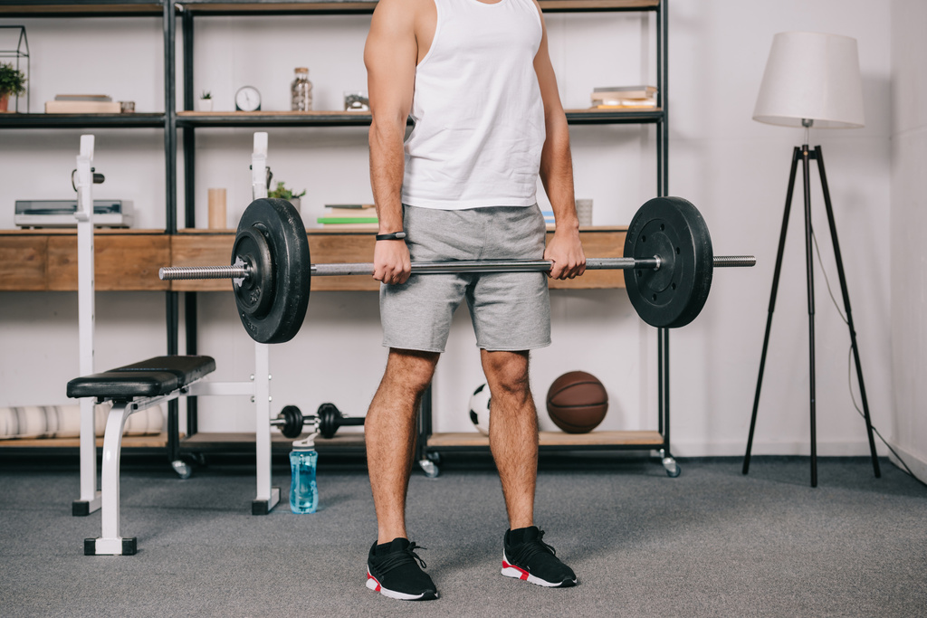 Ausgeschnittene Sicht auf muskulöses Männertraining im heimischen Fitnessstudio  - Foto, Bild
