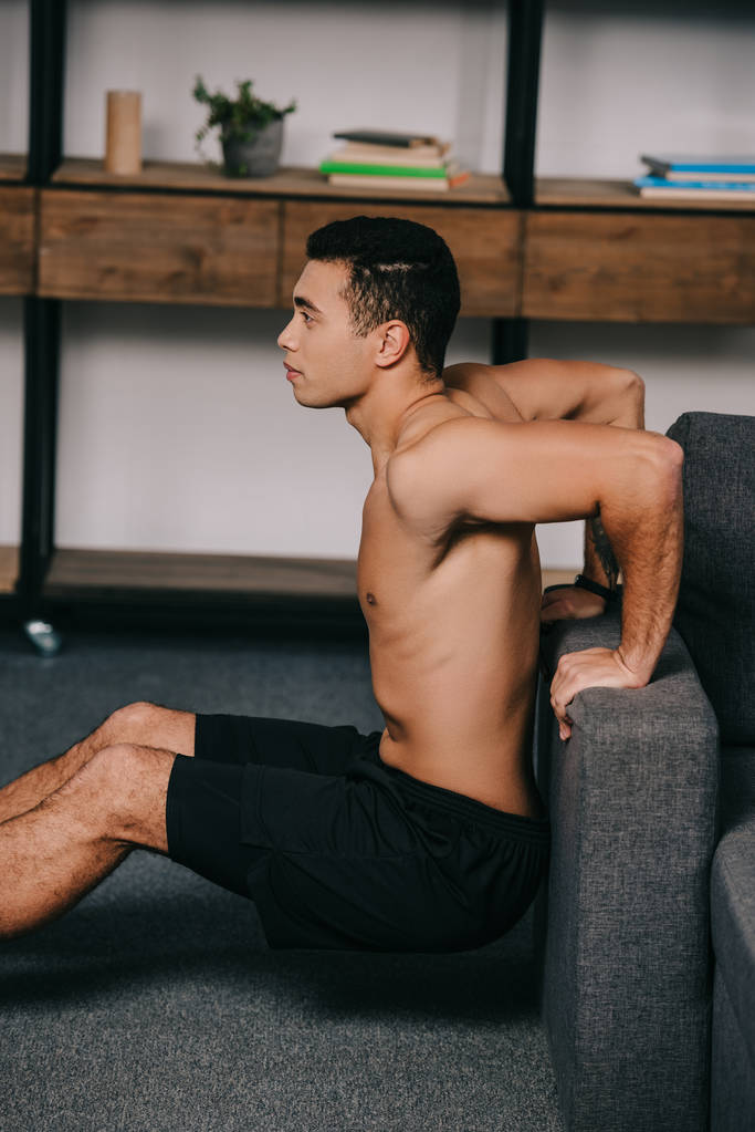 izmos kevert ember edzés közelében kanapéval a nappaliban  - Fotó, kép