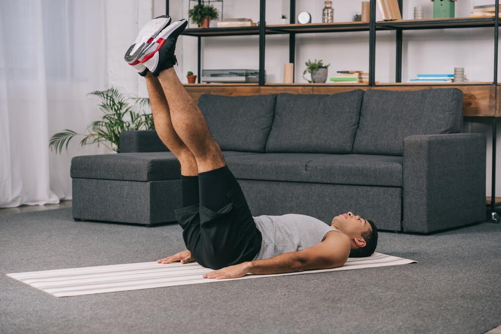 bi-rotu mies makaa kunto matto ja tekee liikuntaa urheiluvaatteet
  - Valokuva, kuva
