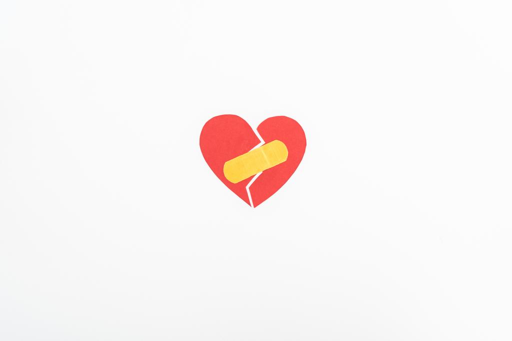 vista desde arriba del símbolo rojo roto del corazón con parche médico aislado en blanco, concepto de San Valentín
 - Foto, imagen