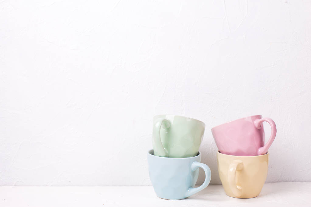 Nahaufnahme von Haufen bunter Teetassen auf weißem Hintergrund - Foto, Bild