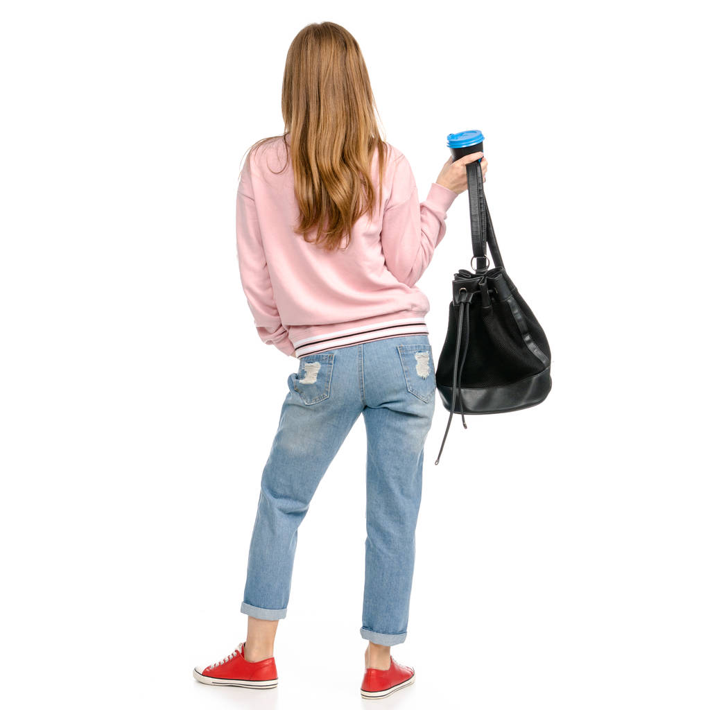 Hermosa mujer en jeans con una mochila caminando va taza de café en la mano
 - Foto, imagen