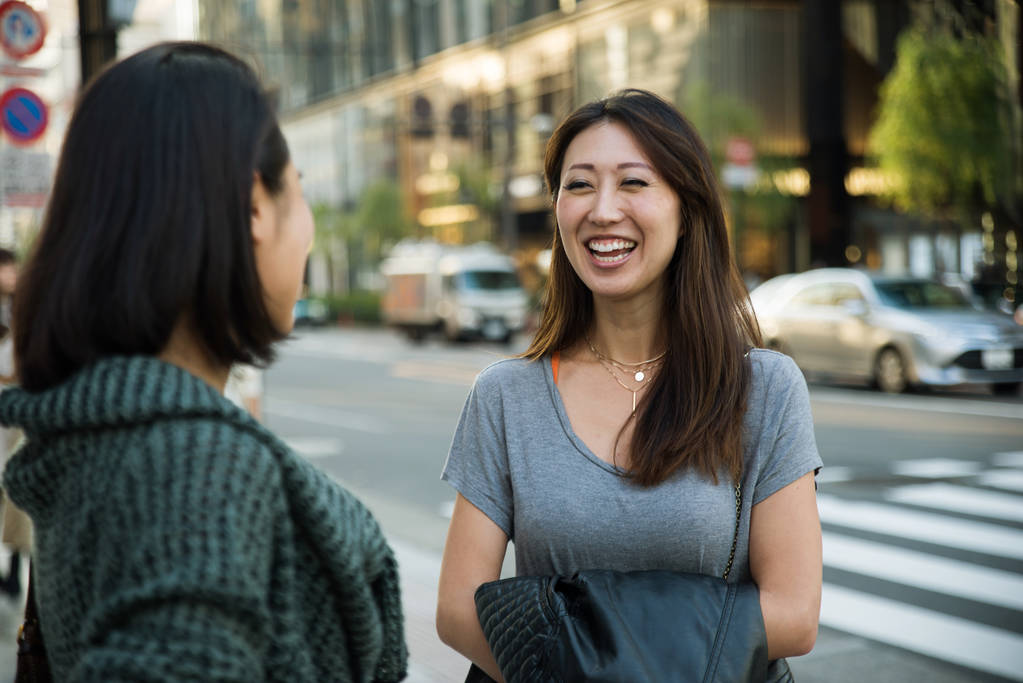 zwei Freundinnen treffen sich draußen und haben Spaß - Japaner verbinden sich auf Tokyos Straßen - Foto, Bild
