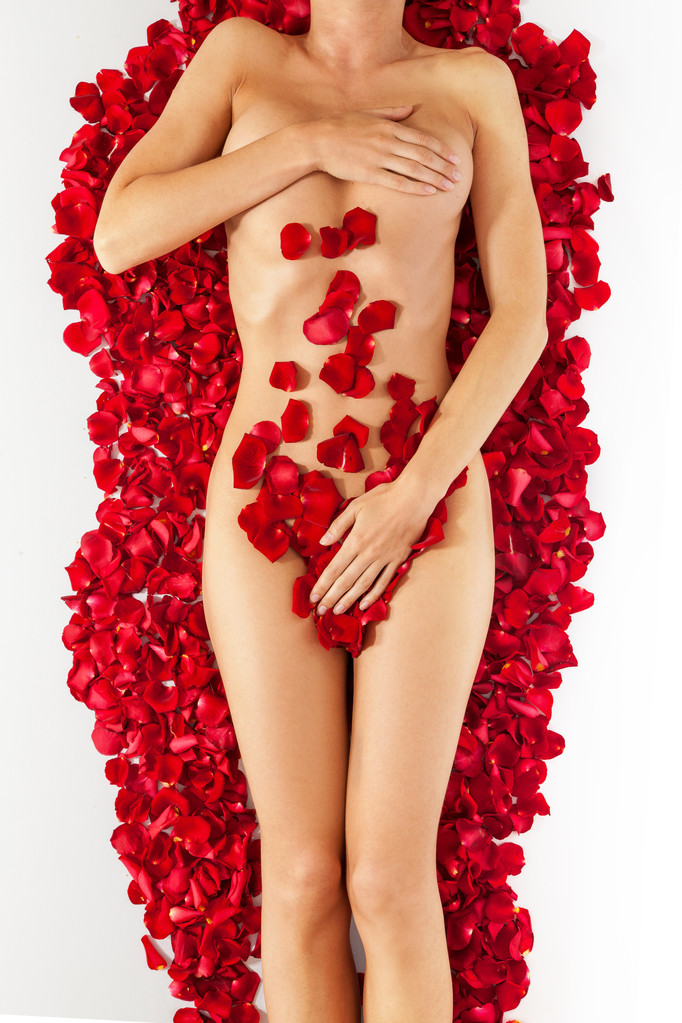 Parte del hermoso cuerpo femenino bronceado desnudo en pétalos de s
 - Foto, Imagen