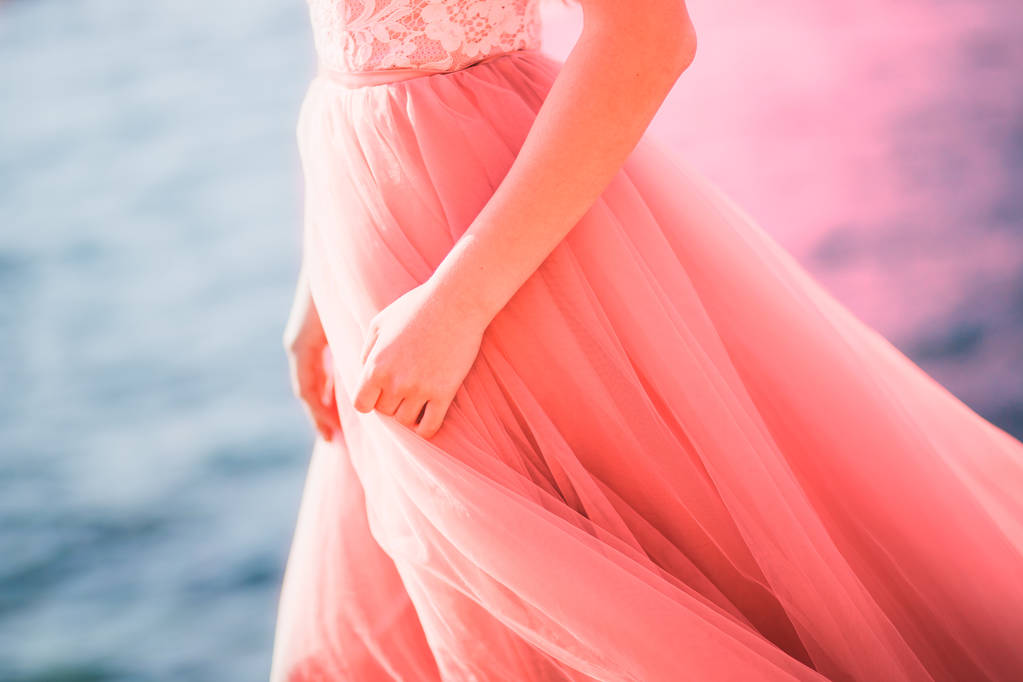 fille en robe rose debout près de la mer gros plan. Le concept de couleurs mode 2019, vivant corail
 - Photo, image