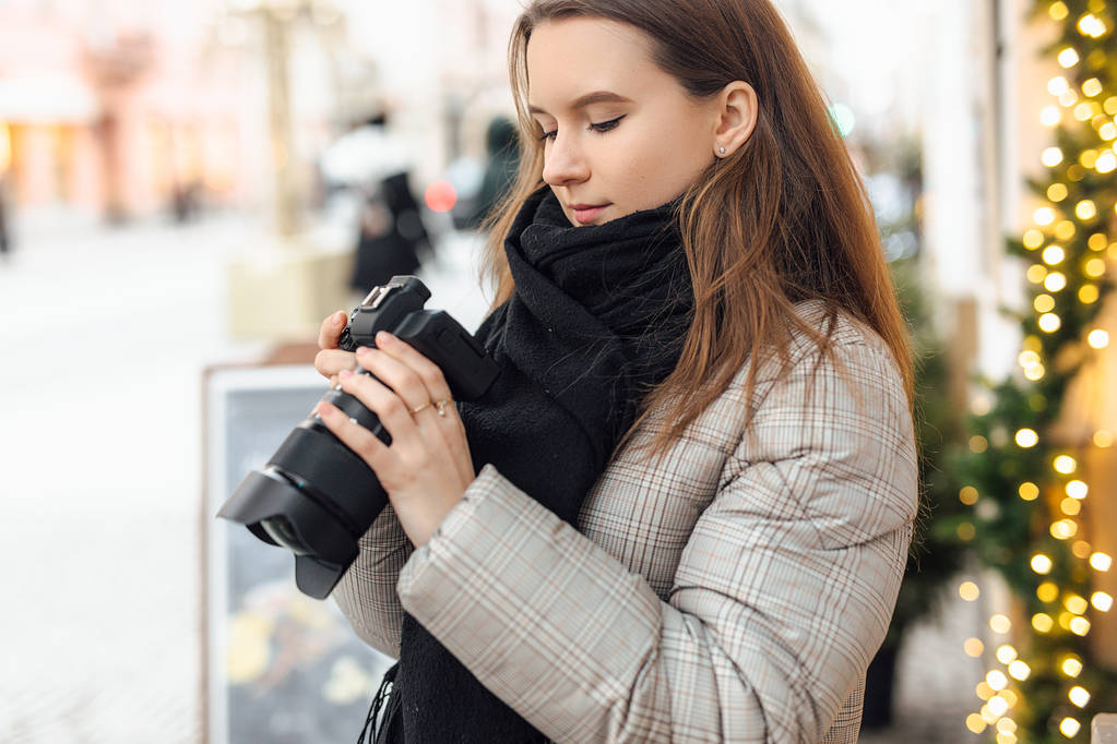 Fotoğrafçı kız sokakta yürümek ve mutlu yüz kamera ile fotoğraf çekmek. Siyah eşarp giyim. Kış, sonbahar kıyafeti. - Fotoğraf, Görsel