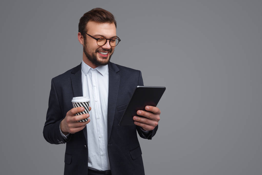 Uomo d'affari con tazza utilizzando tablet
 - Foto, immagini
