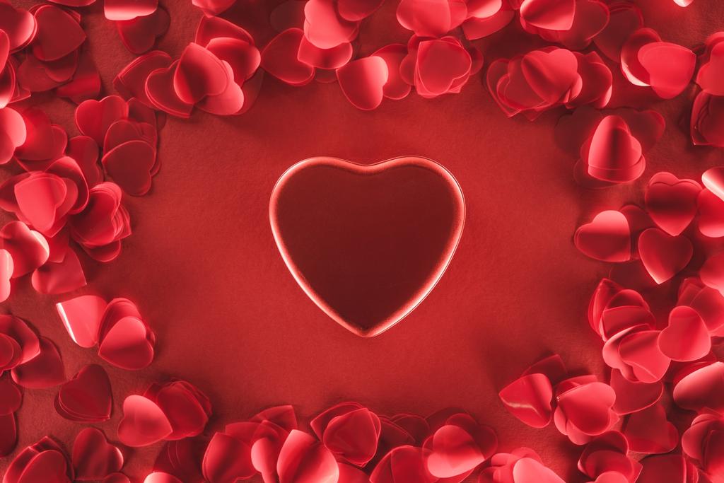 top view of beautiful heart and decorative petals on red background, valentines day concept - Photo, Image