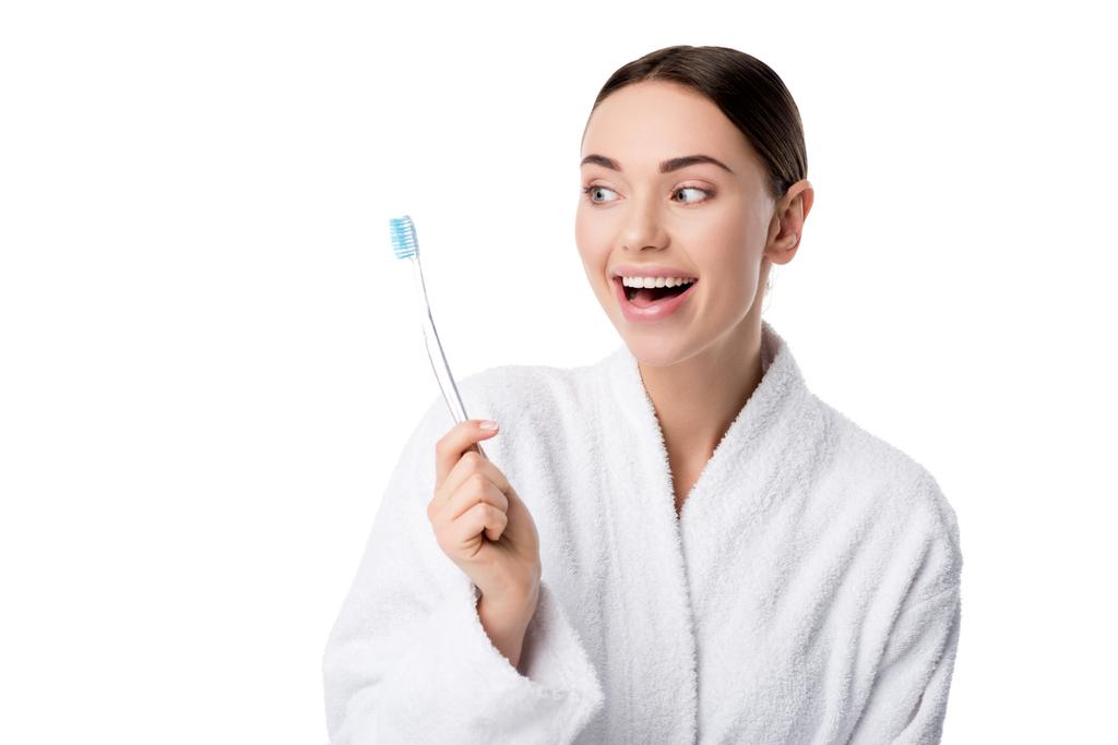 hermosa mujer feliz en albornoz blanco sosteniendo cepillo de dientes aislado en blanco
 - Foto, imagen