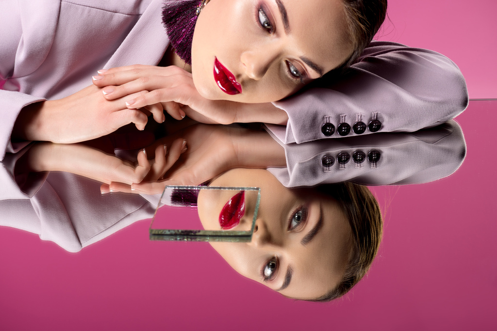 zamyšlený okouzlující žena v formální oblečení odráží v zrcadlech izolované na růžové - Fotografie, Obrázek