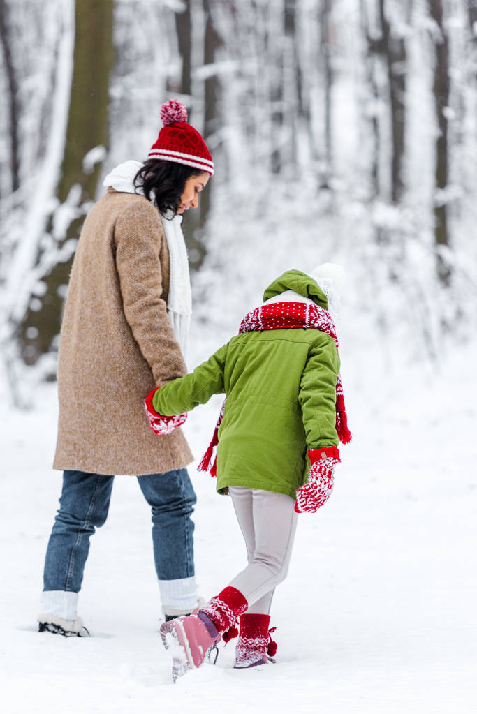 afro-amerikai anya és lánya, gyaloglás, és a kezét a téli park - Fotó, kép