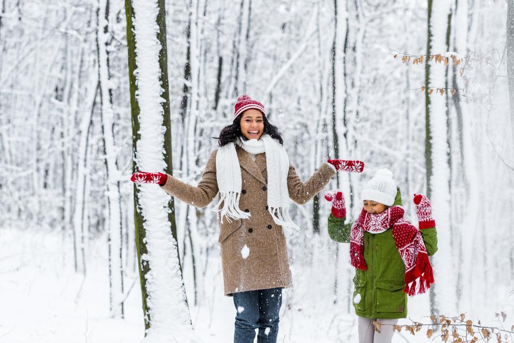 весела афроамериканська жінка і дев'ятнадцять донька кидають сніг в зимовий парк
 - Фото, зображення