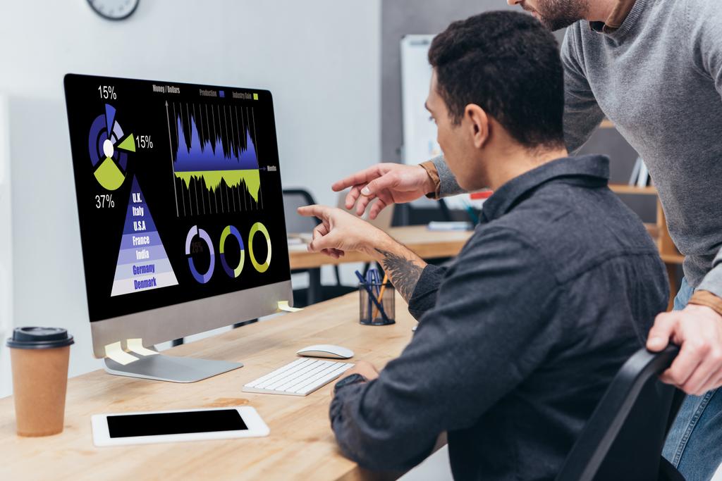обрезанный снимок бизнес-коллег с помощью настольного компьютера с диаграммами и графиками на экране в офисе
 - Фото, изображение