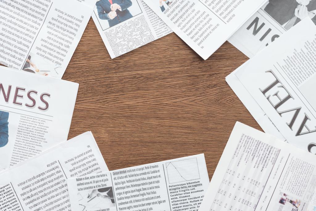 vista elevada de diferentes jornais em mesa de madeira
 - Foto, Imagem