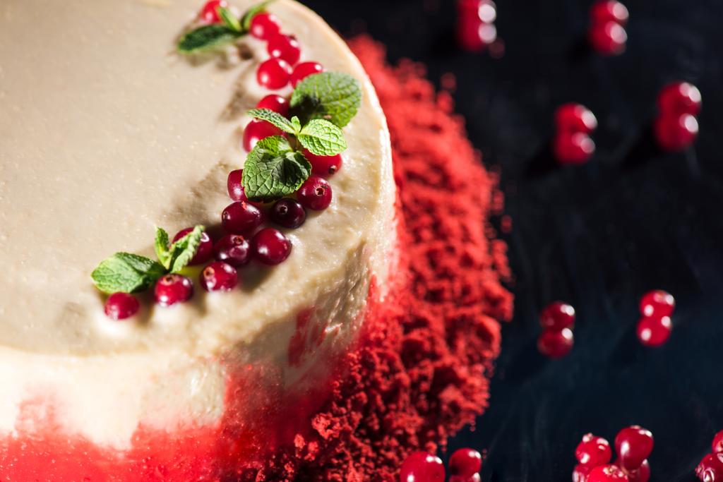 close up of white cake decorated with mint leaves near red currants isolated on black - Photo, Image