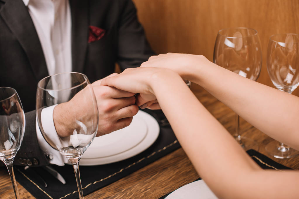 fidanzato e fidanzata che si tiene per mano nel ristorante
 - Foto, immagini