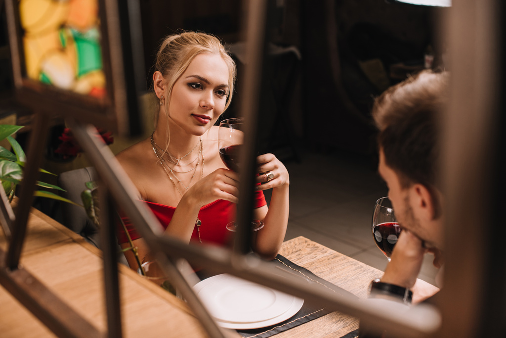 houkutteleva nainen katselee miestä ja flirttailu ravintolassa
  - Valokuva, kuva