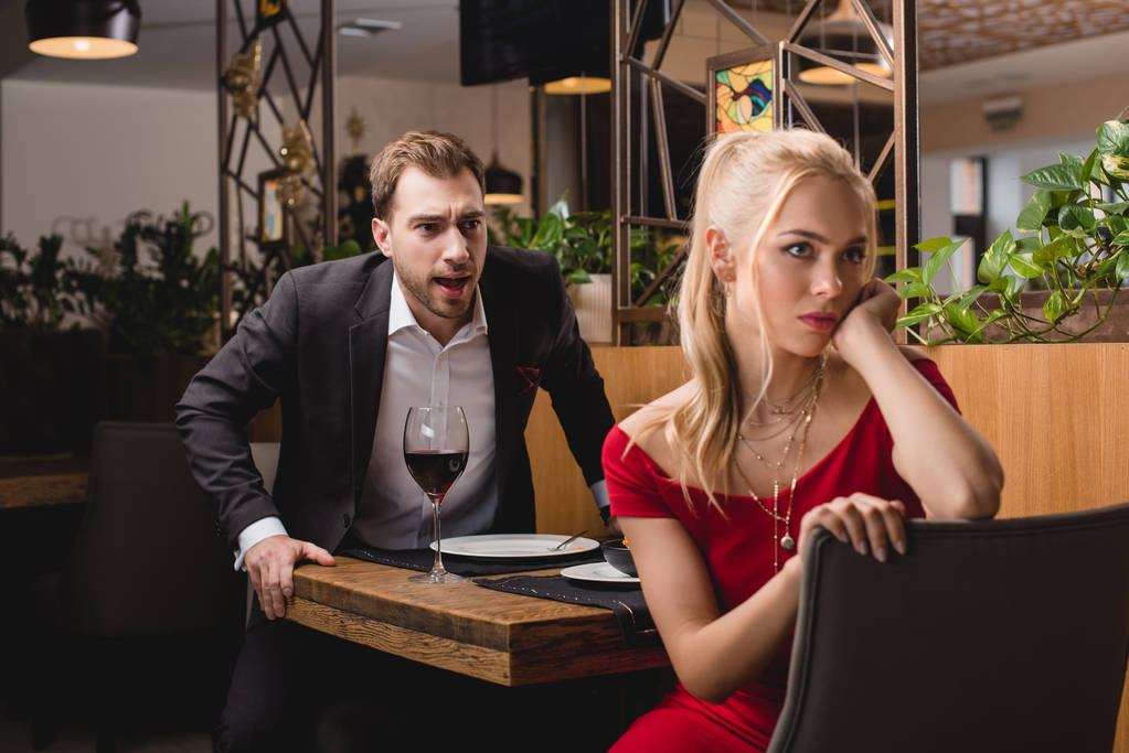foco selectivo de novio gritando a mujer ofendida en el restaurante
  - Foto, Imagen