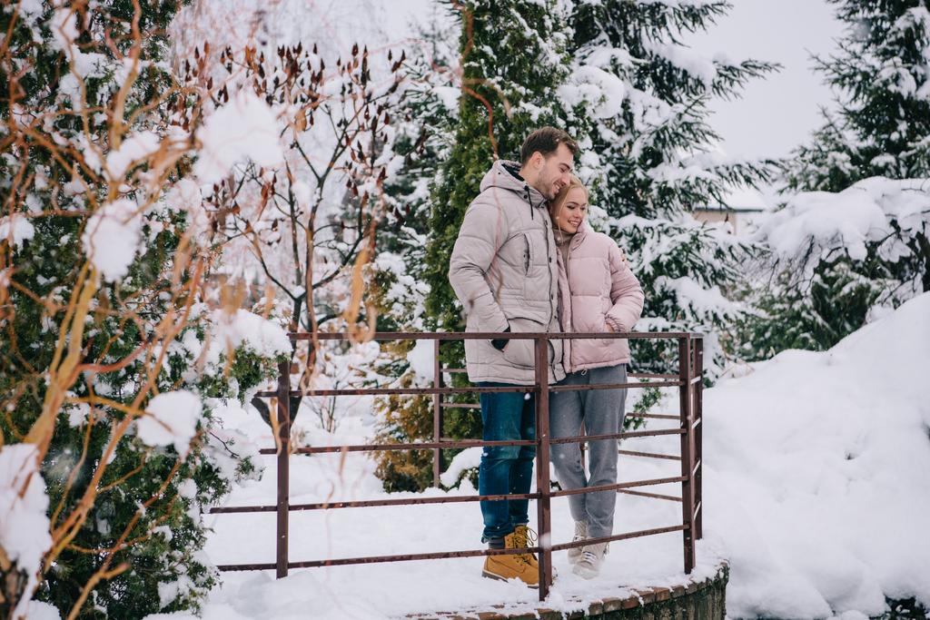 romantische paar staande en knuffelen in winter park  - Foto, afbeelding