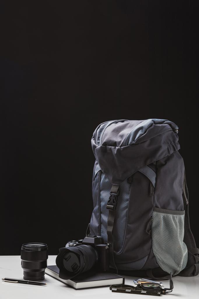 mochila, câmera fotográfica com lente, notebook e equipamento de trekking em preto
 - Foto, Imagem