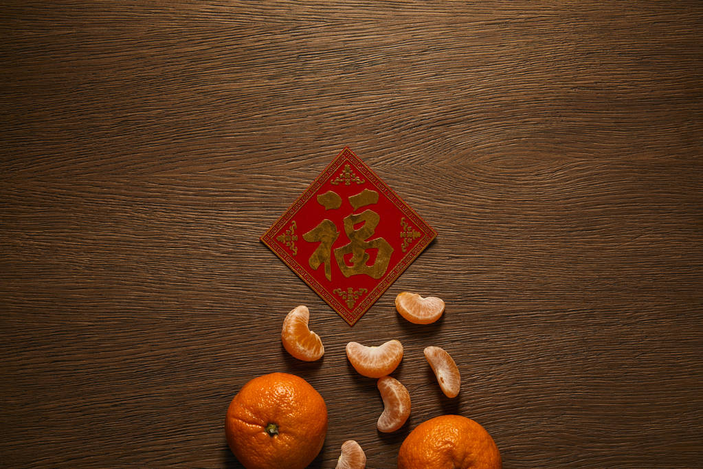 верхний вид свежих спелых мандаринов и золотого иероглифа на деревянный стол
 - Фото, изображение