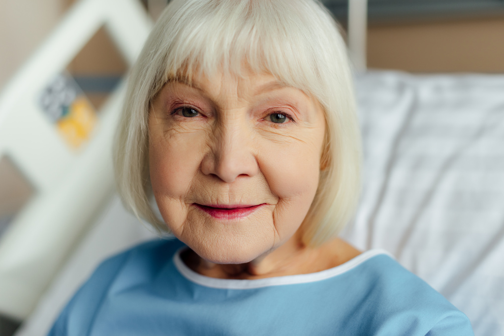 retrato de mujer mayor sonriente con el pelo gris mirando a la cámara en el hospital
 - Foto, imagen