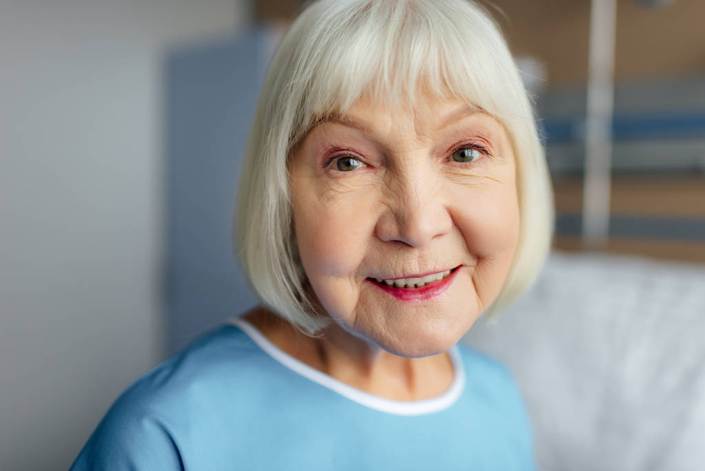 portret szczęśliwy senior kobieta z siwymi włosami, patrząc na kamery w szpitalu - Zdjęcie, obraz