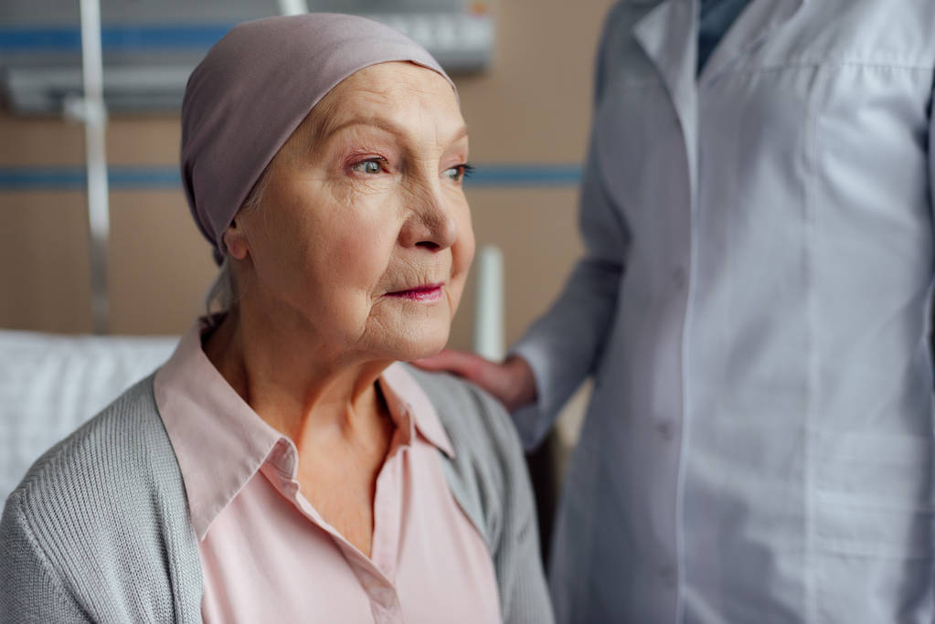 γιατρός εξευμενισμού αναστατωμένος ανώτερων γυναίκα με καρκίνο σε νοσοκομείο - Φωτογραφία, εικόνα