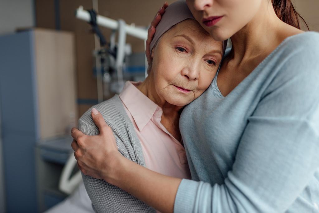 вибірковий фокус дочки обіймає хвору старшу матір з раком в лікарні
 - Фото, зображення