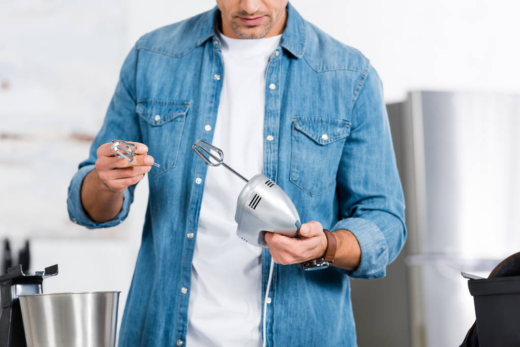 vista recortada del hombre sosteniendo mezclador de cocina y batidor
 - Foto, Imagen