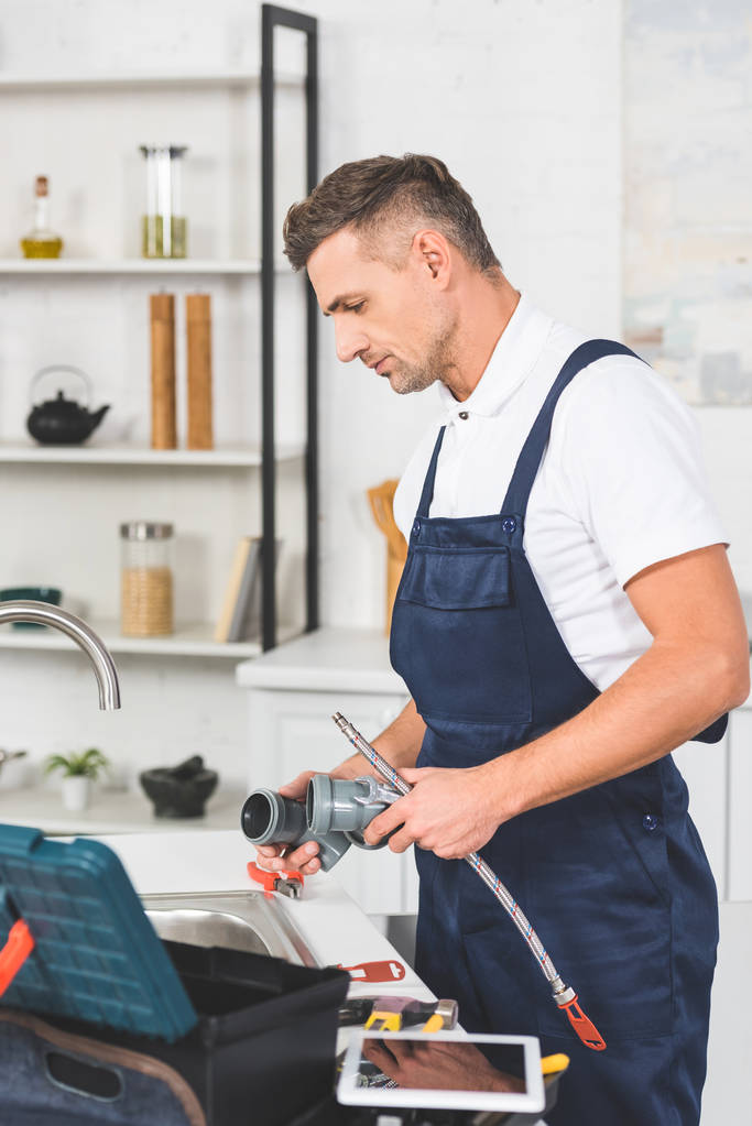 Profil dospělých opravář drží potrubí pro Kuchyně kohoutek opravy  - Fotografie, Obrázek