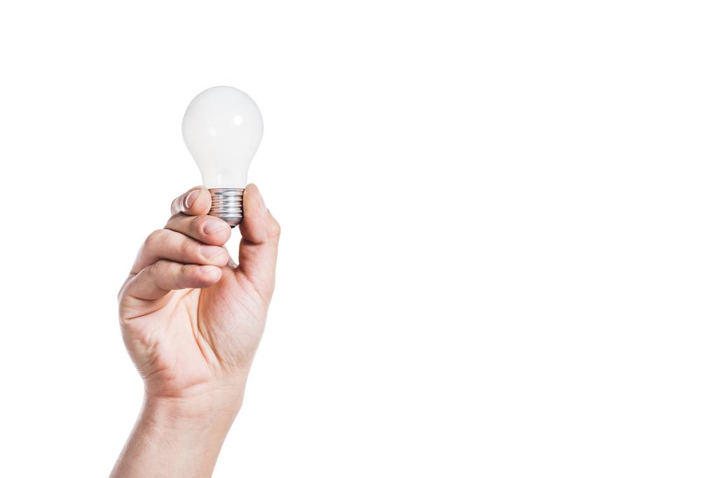 oříznutý pohled člověka drží žárovku izolované na bílém, koncepce energetické účinnosti - Fotografie, Obrázek