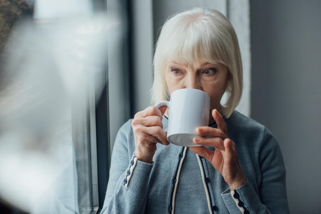 idősebb nő, szürke haj ivó kávé otthon  - Fotó, kép