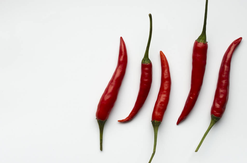 κάτοψη του κόκκινο τσίλι πιπεριές πάνω από το λευκό φόντο - Φωτογραφία, εικόνα
