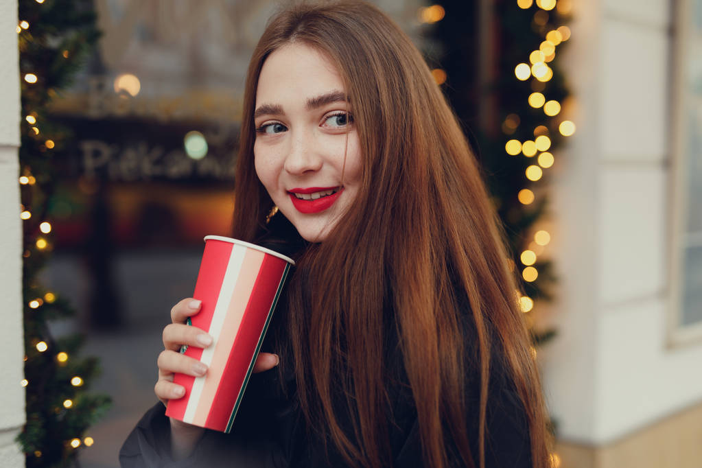 Nő az utcán sétálva vele forró kávét iszom. Télen elegáns mosolygó nő portréja ruhákat forró kávét ivott. Női téli stílus. -Kép - Fotó, kép