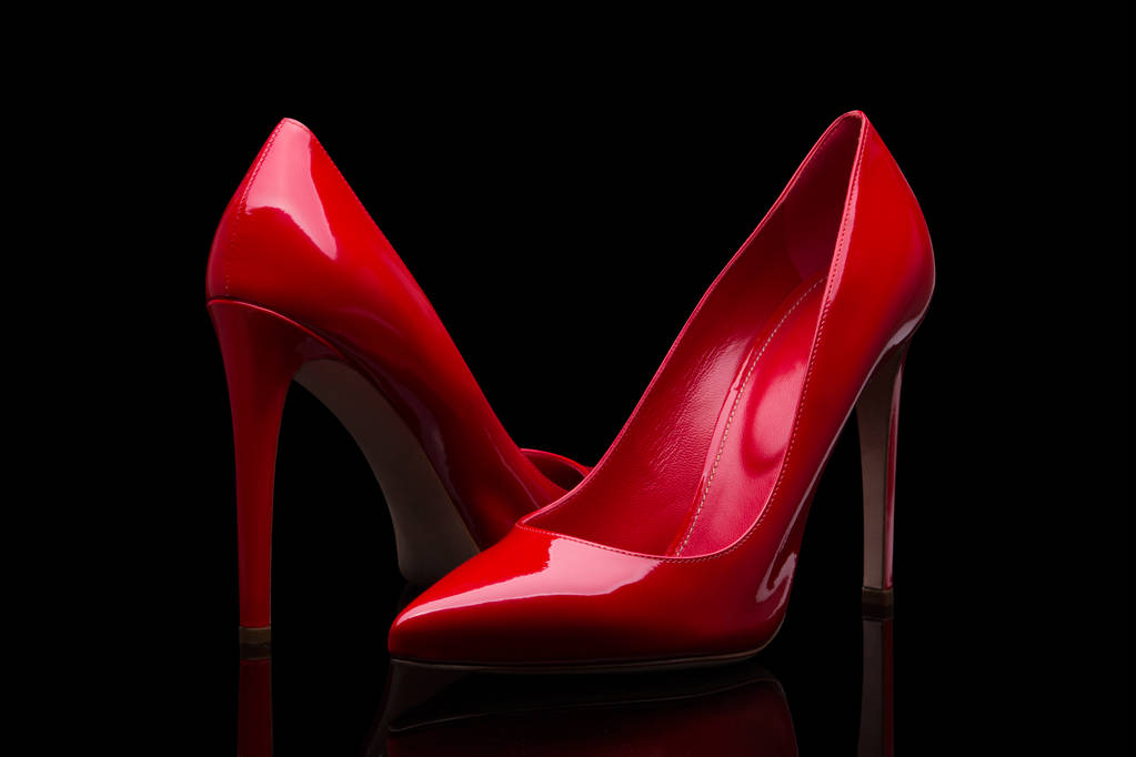 Rode schoenen met hoge hakken en een zwarte achtergrond - Foto, afbeelding