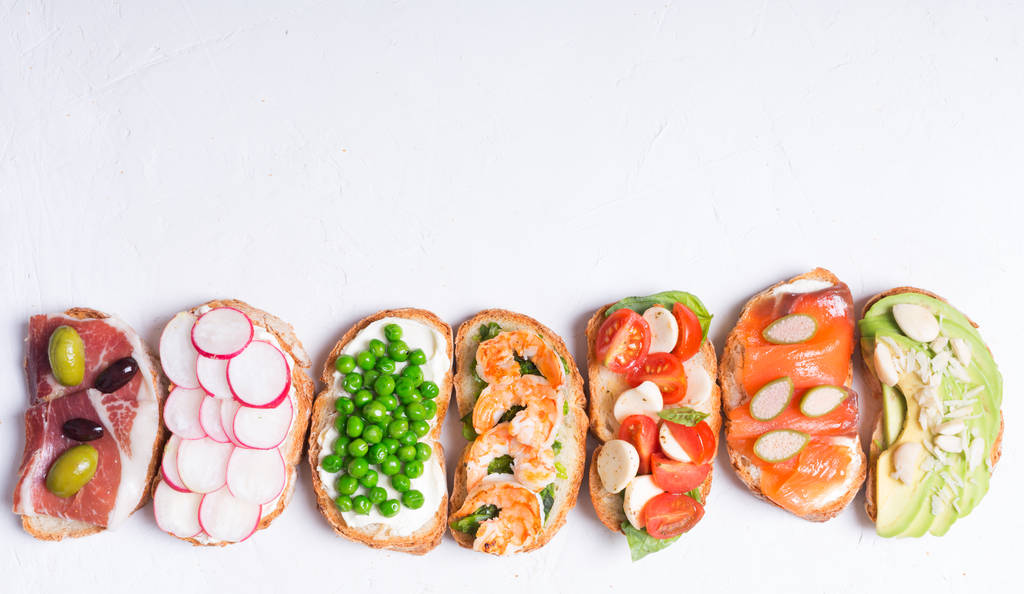 Sandwiches o tapas preparados con pan e ingredientes sabrosos. Podría ser buena comida para un desayuno saludable o para el almuerzo. Orientación horizontal
 - Foto, Imagen