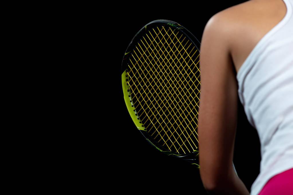 Hermosa chica tenista con una raqueta sobre fondo oscuro con luces
 - Foto, imagen