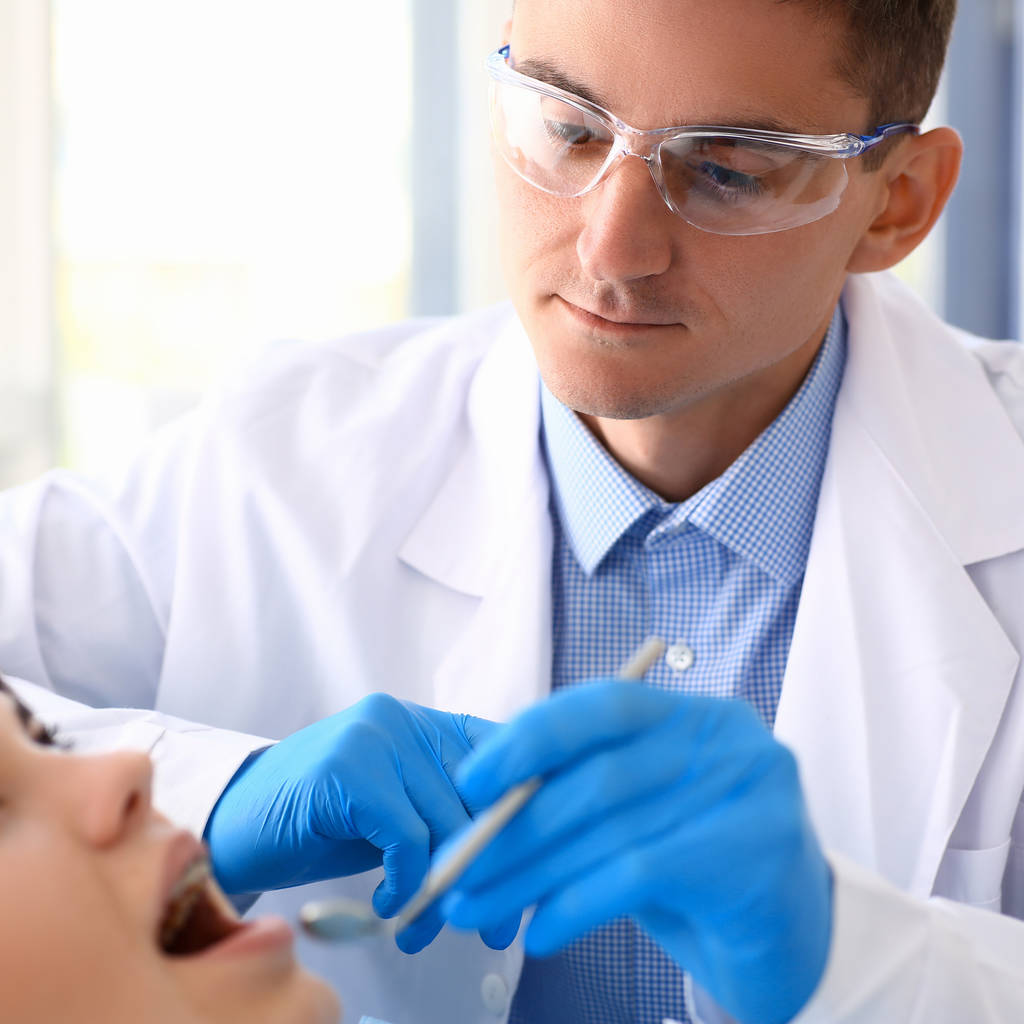 Una mujer en la recepción de un dentista masculino examinando
 - Foto, Imagen
