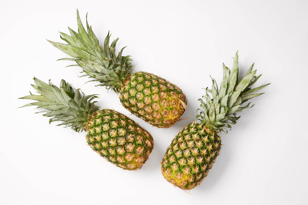 bovenaanzicht van lekkere exotische ananas op witte achtergrond - Foto, afbeelding