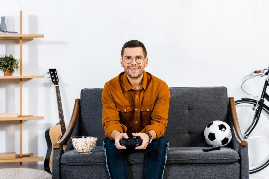 веселий чоловік в окулярах грає в відеогру вдома
 - Фото, зображення