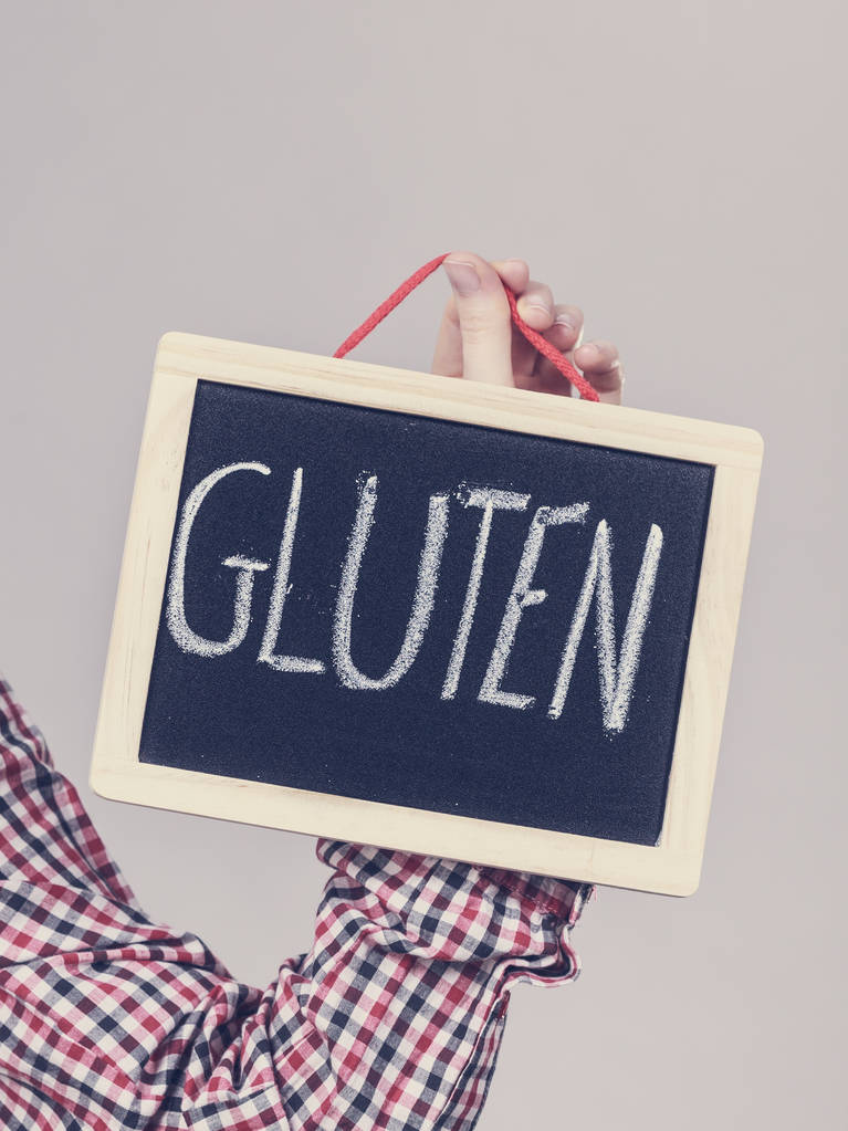 Femme tenant petit tableau noir avec signe gluten. Problème d'allergie boulangerie et pain
. - Photo, image