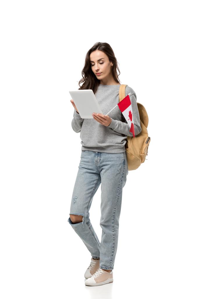 зосереджена студентка, що тримає канадський прапор і використовує цифровий планшет ізольовано на білому
 - Фото, зображення