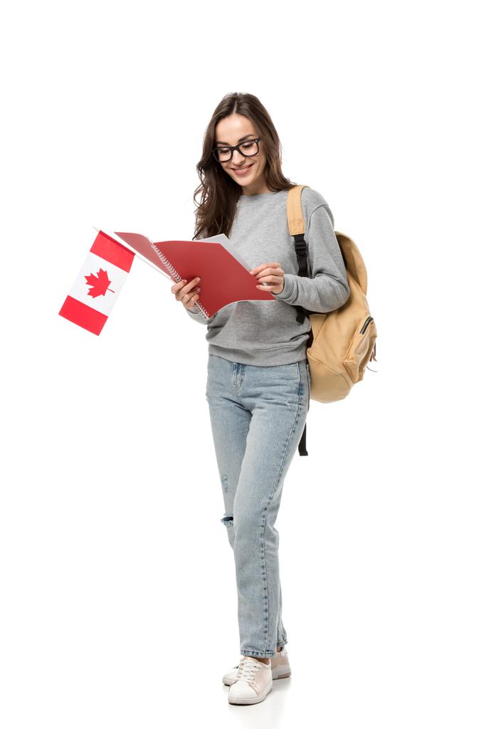 estudante do sexo feminino em óculos segurando bandeira canadense e olhando para notebook isolado em branco
 - Foto, Imagem