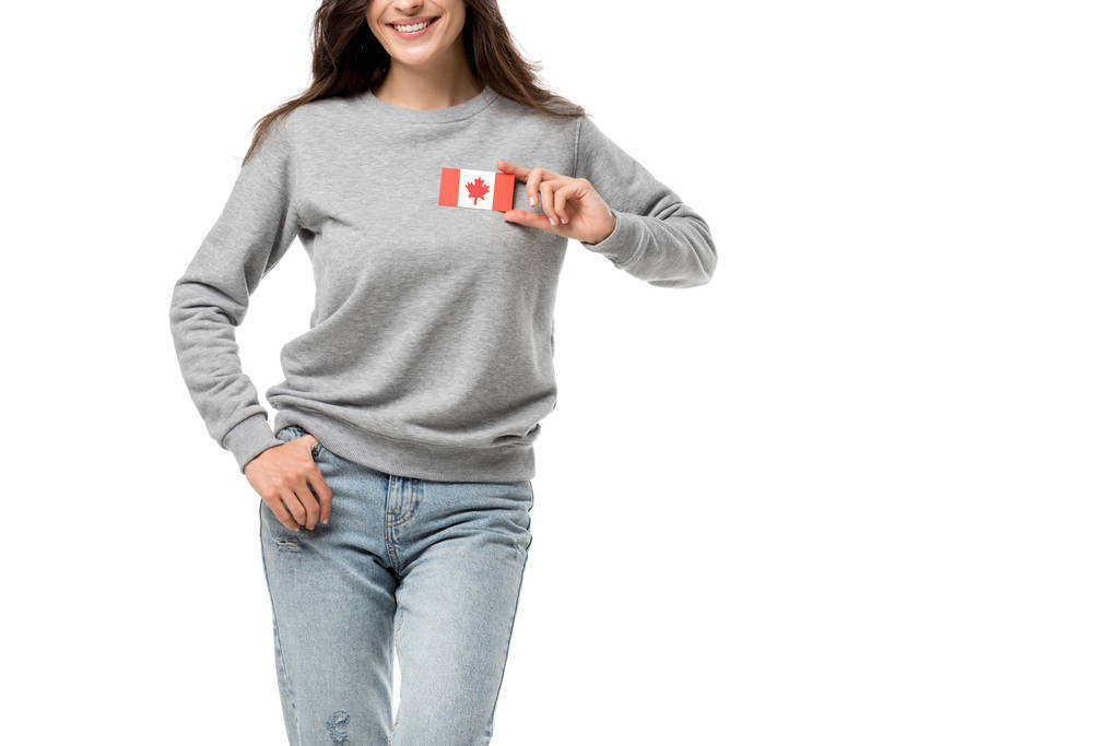 visão parcial da mulher sorridente com crachá de bandeira canadense isolado no branco
 - Foto, Imagem