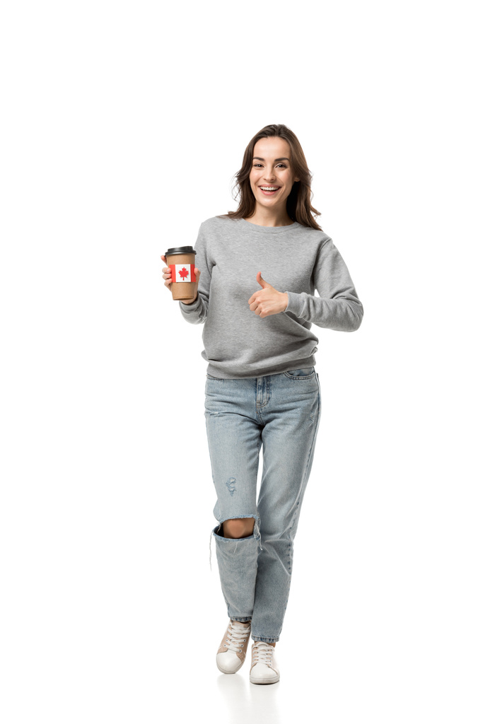 mulher mostrando polegar para cima sinal e segurando xícara de café com bandeira canadense adesivo isolado no branco
 - Foto, Imagem