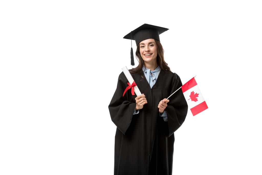 студентка в академическом платье смотрит в камеру и держит канадский флаг с дипломом, изолированным на белом
 - Фото, изображение