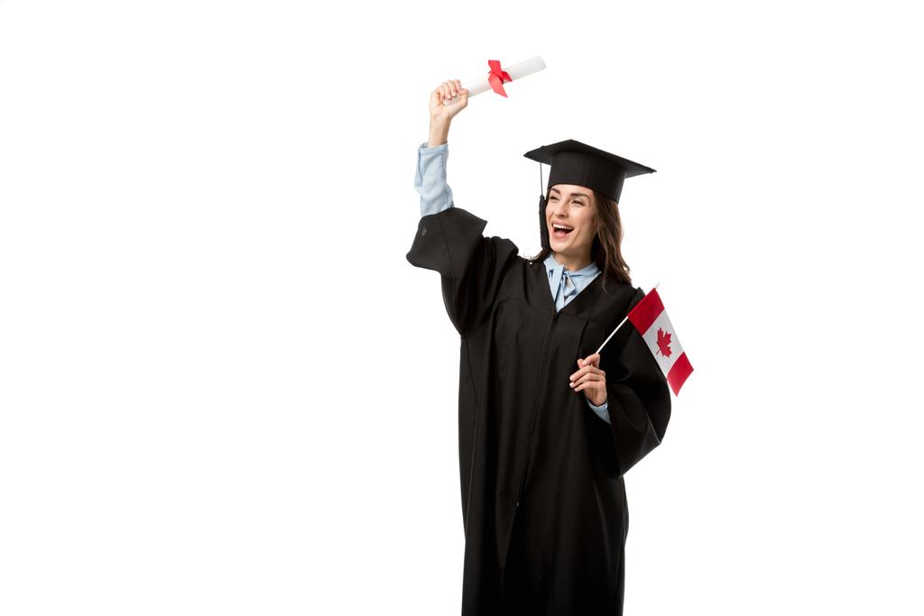 Studentin im akademischen Gewand jubelt und hält kanadische Flagge mit Diplom auf weißem Grund - Foto, Bild