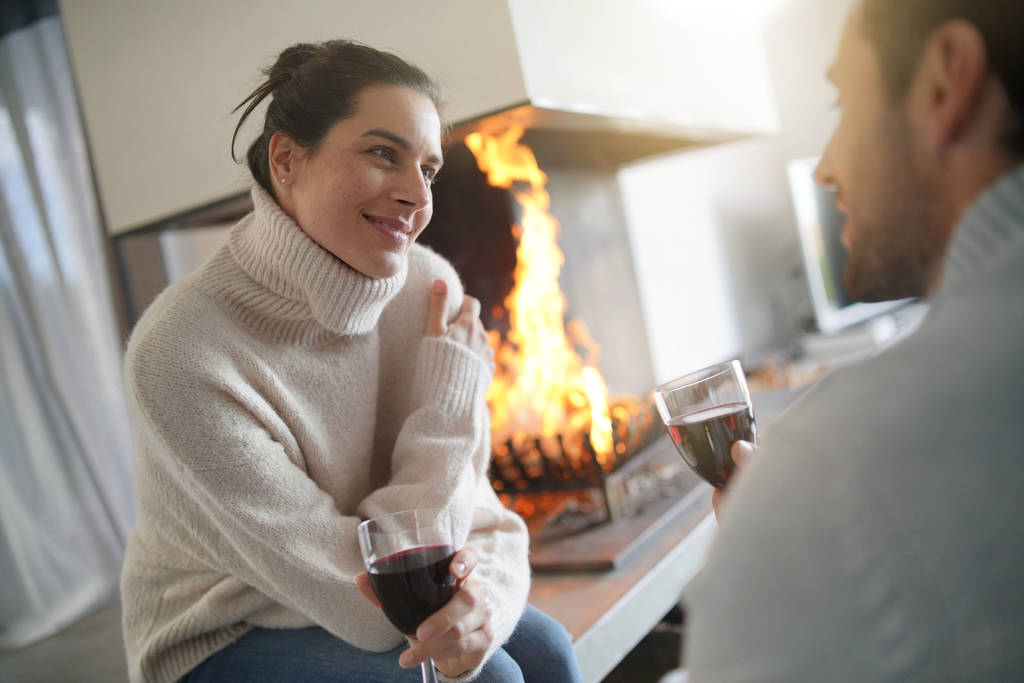  Couple relaxant au coin du feu dégustant des verres de vin rouge
                               - Photo, image